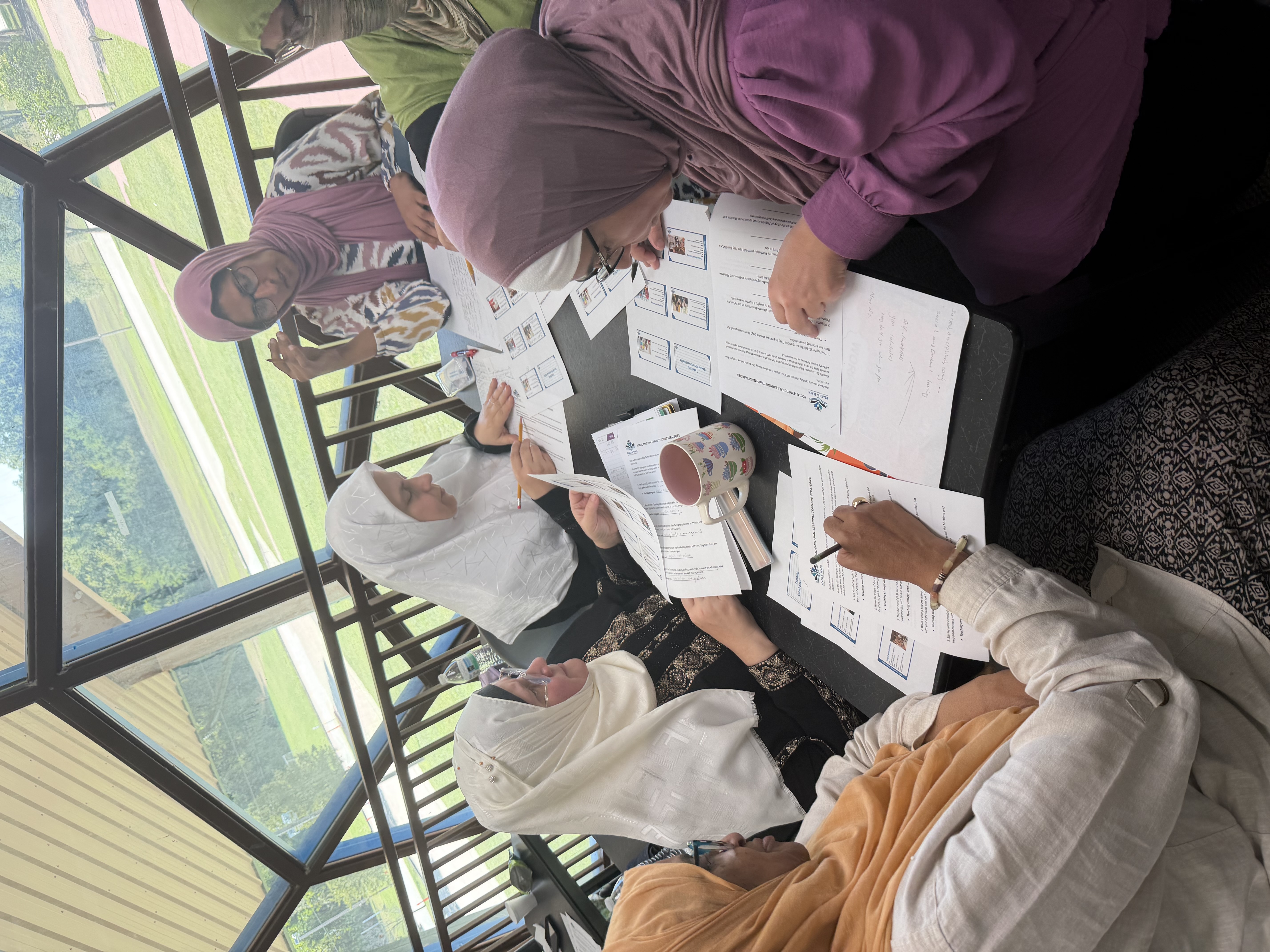 Teachers working through workshop materials at a table